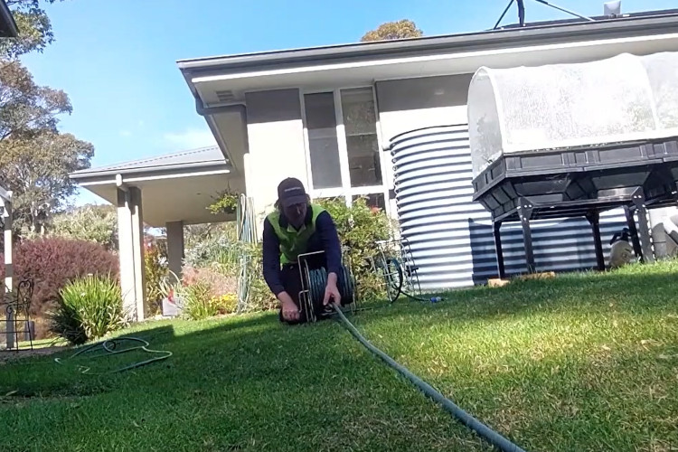 
The nowra downpipe cleaner is finishing his tasks and tidying up, starting with his hose.